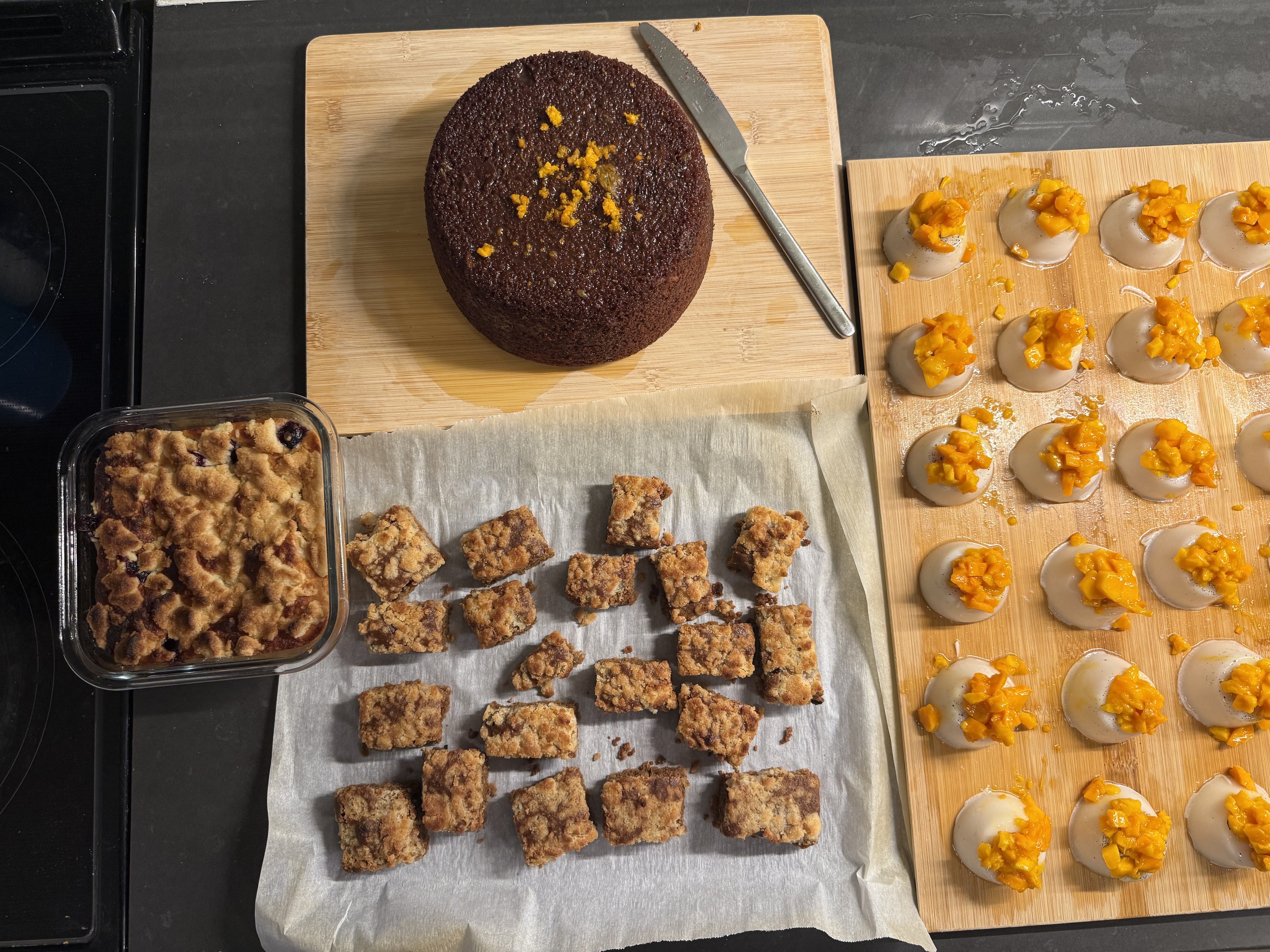 Chai crumble cake featured in the center of my "clear-out-fridge" bake, including a lemon-blueberry crumble cake (left), an orange chocolate cake (top), and a vegan coconut mango panna cotta (right).